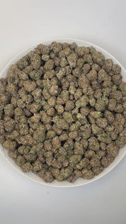 PUFFY Lunch Money is a balanced hybrid THCa strain, created from the fusion of Money Gun and Grape Pie BX. The aroma is funky, with sharp notes of cheese and a hint of savory onions. Visually, dense deep green buds with purple hues and fiery orange pistils are coated in sticky trichomes. Consumers often report an uplifted mood and euphoria, accompanied by a balanced cerebral buzz, relaxed body sensation, and mellow focus.