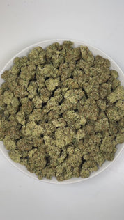 PUFFY Peach Ringz is an indica-dominant hybrid THCa strain born from the flavorful cross of Marionberry and Eddy OG. The aroma bursts with gassy, sweet, and fruity notes, creating an enticing and vibrant sensory experience. Visually, the buds are bushy and densely packed, covered in glistening trichomes with minty  green tones and dark olive undertones. Consumers frequently describe this strain as offering a harmonious experience, starting with a light, uplifting mental clarity that brightens the mood, foll