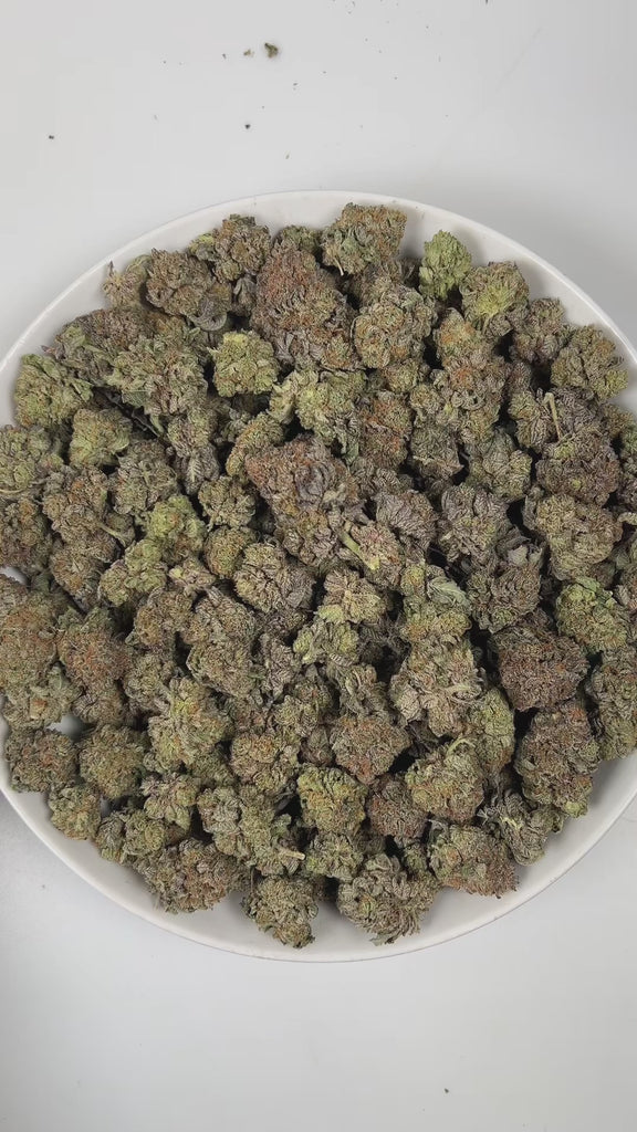 PUFFY Bubba Kush is an indica-dominant hybrid THCa strain, crafted from the legendary lineage of OG Kush × Afghani Indica. The aroma is a captivating blend of sharp gasoline, sweet bubblegum, and earthy woody notes, creating a strikingly bold yet playful scent profile. Visually striking, the buds are dense and resin-packed, shimmering with frosty trichomes over deep green and purple hues accented by bright orange hairs. Consumers often describe the effects as a wave of full-body relaxation that eases stress
