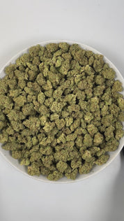 PUFFY Wedding Cake (smalls) is an indica-dominant hybrid THCa strain created by crossing Triangle Cherry Pie and Girl Scout Cookies (GSC). The aroma unfolds with rich, creamy vanilla, complemented by smooth, comforting earthy undertones. Visually, the buds are dense and vibrant, with forest green and purple hues coated in frosty trichomes and bright orange pistils. Consumers often report a euphoric, uplifted mood paired with a relaxing body high, along with a creative and social spark in lighter use.