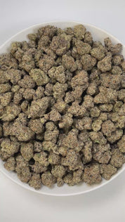PUFFY Amarena de Limon is a sativa-dominant hybrid THCa strain, born from the legendary cross between Gelato 41 × ZKZ. The aroma bursts with sharp gassy notes, zesty lemon brightness, and a pungent chemical edge for a bold, unforgettable profile. Visually, the buds appear thick and rounded, showcasing dark green tones with flashes of purple, blanketed in shimmering trichomes and highlighted by vibrant orange pistils. Consumers often describe it as delivering a lively, mood-brightening high that boosts creat