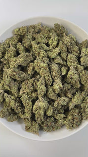 PUFFY Do-Si-Do is an indica-dominant hybrid THCa strain, born from the legendary cross of Girl Scout Cookies (GSC) × Face Off OG. A bold aroma that opens with sharp gassy notes, layered with a sweet candy-like undertone and finished with a distinct chemical edge, creating a pungent yet intriguing profile. Visually striking, with dense medium buds in deep green and purple tones, accented by bright orange pistils and a frosty coat of milky-white trichomes. Consumers often report a calming body high with uplif