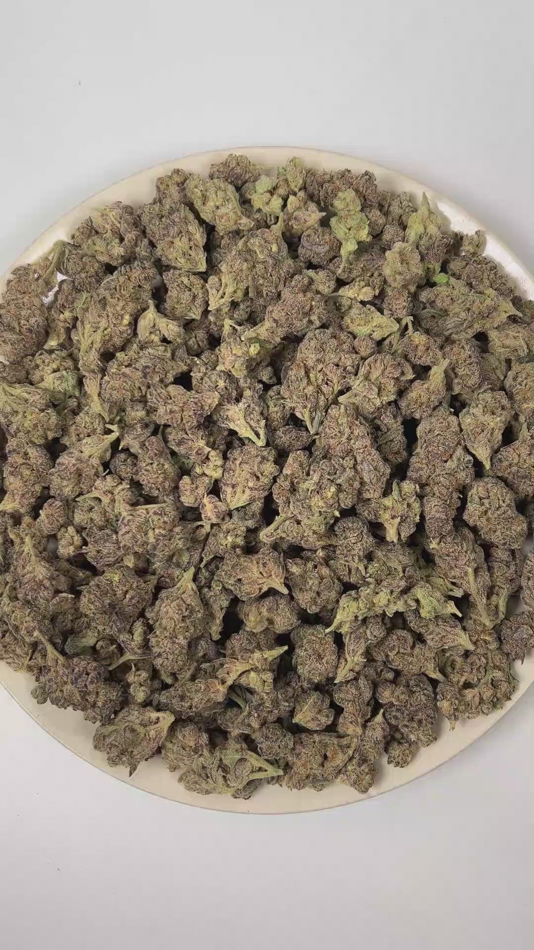 PUFFY Glitter Bomb is an indica-dominant hybrid THCa strain born from the flavorful cross of Grape Gas #10 and OGKB Blueberry Headband. The aroma unfolds with a vibrant burst of ripe berries layered over bright, zesty citrus notes, rounded out by a deep, gassy undertone. Visually, the buds are dense and deep forest green with striking purple hues, bright orange pistils, and a heavy coating of sparkling white trichomes. Consumers report a bright rush of cerebral uplift that gently settles into a soothing, fu