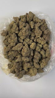 PUFFY GMZ is a potent hybrid THCa strain born from a cross between GMO Cookies and ZCubed (Zkittlez × OG Kush). This cultivar boasts a deep, rich aroma that blends earthy tones with smooth, smoky undertones, creating an inviting and grounding scent profile. Visually striking, its dense, chunky conical nugs range in color from mint to forest green, accented by vibrant orange pistils and a generous coating of milky white crystal trichomes. Consumers often report an intense wave of euphoria that gradually melt