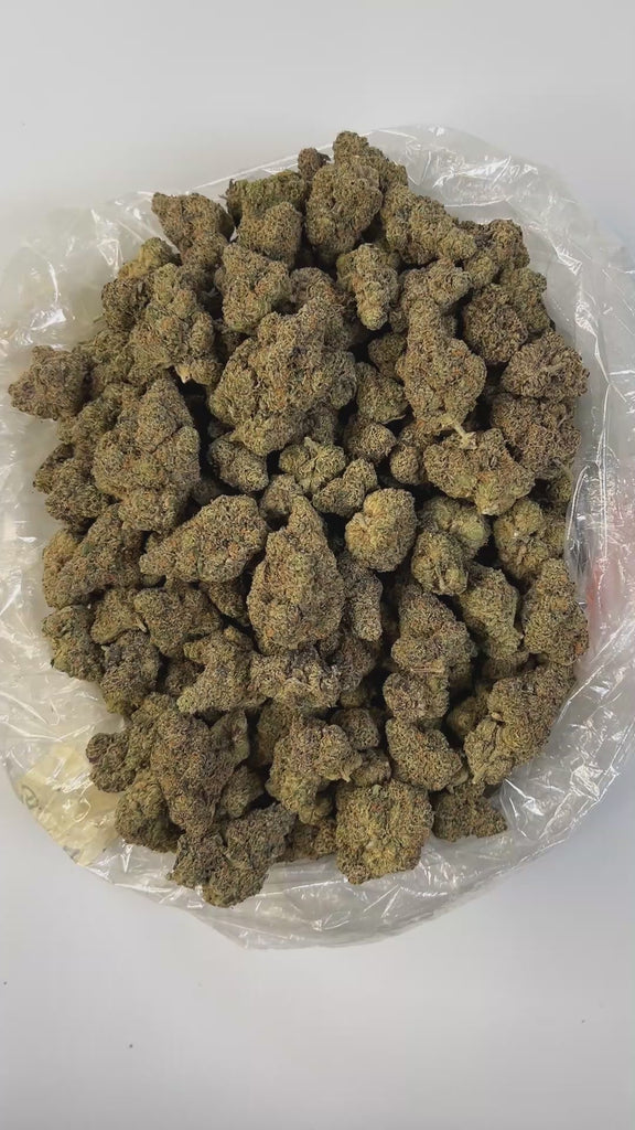 PUFFY GMZ is a potent hybrid THCa strain born from a cross between GMO Cookies and ZCubed (Zkittlez × OG Kush). This cultivar boasts a deep, rich aroma that blends earthy tones with smooth, smoky undertones, creating an inviting and grounding scent profile. Visually striking, its dense, chunky conical nugs range in color from mint to forest green, accented by vibrant orange pistils and a generous coating of milky white crystal trichomes. Consumers often report an intense wave of euphoria that gradually melt