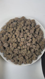 PUFFY Original Z is an indica-dominant hybrid THCa strain, carefully crafted by blending the celebrated genetics of Grape Ape and Grapefruit with a secret third strain. The aroma delights the senses with sweet, candy-like notes, juicy tropical fruit undertones, and bright, zesty accents that create a lively and playful scent. Visually, the dense buds display bright green hues with hints of purple, highlighted by vibrant orange pistils and a thick, frosty coating of trichomes. Consumers often report a eupho
