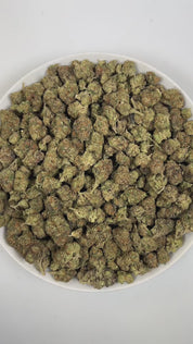 PUFFY Double Baked Cake is an indica-dominant hybrid THCa strain, born from the flavorful union of Layer Cake and Wedding Cake. The aroma is a robust mix of herbal, earthy, and gassy notes, giving it a rich and pungent character. Visually, it features dense light green buds with purple hues and vibrant orange pistils, all coated in a frosty layer of sticky trichomes. Consumers often report a relaxing body high that begins with an uplifting, mood‑enhancing onset of calm, happy sensations before gradually mel