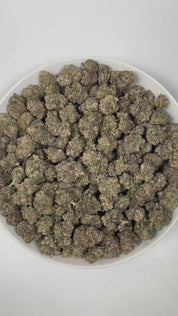 PUFFY Grape Gelato is an indica-dominant hybrid THCa strain, born from the renowned fusion of Grape Kush and Gelato #33. The aroma is a delightful blend of sweet grape, juicy tropical fruits, and a playful candy-like essence that instantly entices the senses. Visually, dense green buds with purple hues and fiery orange pistils are coated in sticky trichomes. Consumers often report a euphoric, energetic, and happy high that encourages lighthearted conversation and social ease while delivering a relaxing, moo
