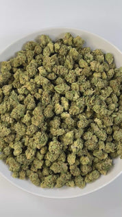 PUFFY Mule Fuel (smalls) is a hybrid THCa strain, crafted from a genetic cross of Lurch and GMO Cookies. The aroma is bold and pungent, with sharp peppery notes, a robust garlicky undertone, and the unmistakable fuel-like scent of diesel. Visually, the buds are dense and compact, showcasing a vibrant olive-green color and a sparkling layer of trichomes. Consumers often report a deeply relaxing experience, characterized by waves of euphoria, soothing calm, a heavy, calming body melt, and a blissful sense of 
