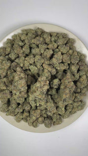 PUFFY Mac (Miracle Alien Cookies) is a balanced hybrid THCa spawned through the strategic pairing of Alien Cookies × (Colombian × Starfighter). The aroma combines skunky musk, sharp cheesy notes, and a strong, pungent scent. Visually, dense forest green buds with hints of purple are threaded with fiery orange pistils and coated in a sparkling layer of sticky trichomes. Consumers often report feelings of euphoria, an uplifted mood, relaxation, and enhanced creativity.