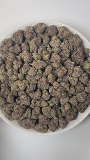 PUFFY Laffy Taffy is a sativa-dominant hybrid THCa strain, born from the flavorful cross of Banana OG and Pestilence. The aroma is a delightful blend of sweet candy, juicy berries, and subtle earthy undertones. Visually, the buds are dense and striking, showcasing deep green and rich purple hues, accented by bright orange pistils and a sparkling layer of trichomes. Consumers often report an uplifting and euphoric high that brings happiness, energy, and mental clarity, fostering creativity and focus, while g