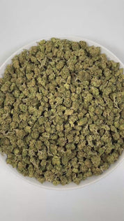 PUFFY Almond Mochi (smalls) is a balanced hybrid THCa strain, crafted from the flavorful cross of Mochi and Biscotti Dough. The aroma is a bold and intriguing blend of diesel, nutty undertones, and a subtle hint of vanilla, creating a rich and inviting scent profile. Visually, dense deep green buds with hints of purple are threaded with fiery orange pistils and coated in a sparkling layer of sticky trichomes. Consumers often report a balanced high combining happy, creative, and euphoric effects with calming