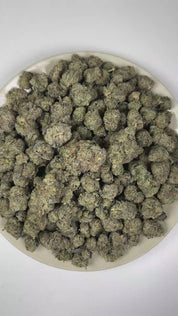 PUFFY Octane Mintz is an indica-dominant hybrid THCa strain resulting from a unique blend of Sunset Octane and Wedding Cake. The aroma features a pungent fuel-like scent complemented by refreshing mint notes and a distinct gassy undertone. Visually, dense forest green buds with purple hues and fiery orange pistils are coated in sticky trichomes. Consumers often report feeling euphoric and uplifted, followed by a deep sense of relaxation and calm that leaves them feeling at ease and content.