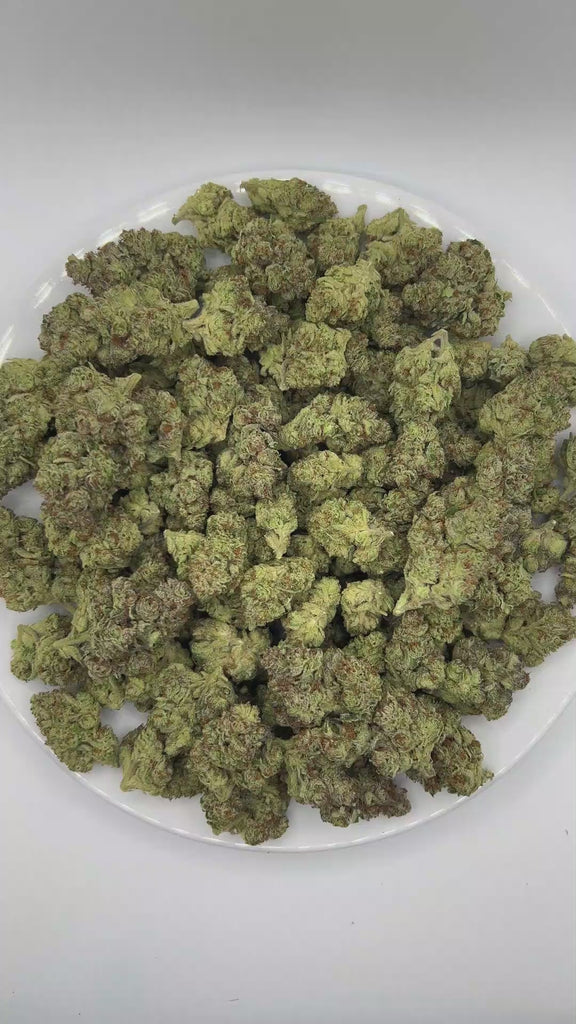 PUFFY GMO, also known as Garlic Cookies, is an indica-dominant hybrid THCa strain crafted from the legendary lineage of Girl Scout Cookies and Chemdawg. The aroma is rich with savory notes of onion and garlic, finishing with a distinctly savory character. Visually, dense deep forest green buds with purple hues and fiery orange pistils are coated in sticky trichomes. Consumers often report euphoric and uplifting mental effects that elevate mood and promote a positive mindset, followed by deep physical relaxa