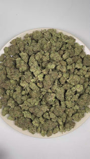 PUFFY Dulce De Uva is an indica-dominant THCa strain, born from the flavorful cross of Grape Pie and OG Kush. The aroma is intensely pungent, with sharp garlic notes layered over a robust onion-like earthiness. Visually, dense deep green buds with purple hues and fiery orange pistils are coated in sticky trichomes. Consumers often report experiencing happiness and mild euphoria, accompanied by a soothing relaxation of both mind and body. 