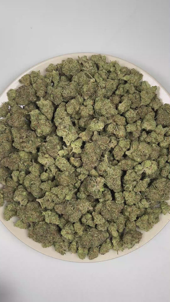 PUFFY Dulce De Uva is an indica-dominant THCa strain, born from the flavorful cross of Grape Pie and OG Kush. The aroma is intensely pungent, with sharp garlic notes layered over a robust onion-like earthiness. Visually, dense deep green buds with purple hues and fiery orange pistils are coated in sticky trichomes. Consumers often report experiencing happiness and mild euphoria, accompanied by a soothing relaxation of both mind and body. 