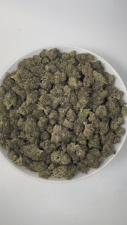 PUFFY Venom OG is an indica-dominant THCa strain, born from the powerful cross of Poison OG and Rare Dankness #1. The aroma greets you with a bold blend of diesel, delicate floral notes, and rich earthy undertones, creating a captivating sensory experience. Visually striking, this strain showcases dense forest-green buds kissed with deep purple hues, fiery orange pistils, and a sparkling layer of sticky, resinous trichomes. Consumers often report a soothing body high paired with elevated mood, bringing feel