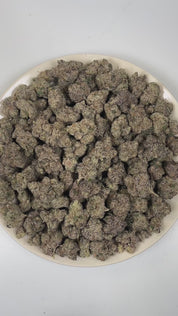PUFFY Purple Pez is a balanced hybrid THCa strain created through the indulgent cross of Purple Punch and Candy Kush. The aroma delivers a bold fusion of ripe grape, sweet candy-like notes, and sharp gasoline fuel undertones. Visually, dense forest green buds with purple hues and fiery orange pistils are coated in sticky trichomes. Consumers often report an initial euphoric and happy mental uplift with enhanced creativity, followed by a gently relaxing body high that promotes calmness.
