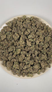 PUFFY Bolo Runtz is an indica-dominant hybrid THCa strain bred from the exceptional pairing of Gelato and Original Z. The aroma is rich and layered, blending dank, fruity sweetness with a bold, gassy undertone. Visually, the buds are dense and vibrant, showcasing vivid green and deep purple hues, accented by bright orange pistils and a generous coating of sparkling trichomes. Consumers often report a balanced high that begins with a euphoric cerebral lift and gradually settles into a soothing body effect.