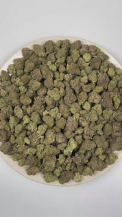 PUFFY Cherry Cough Syrup is an indica-dominant hybrid THCa strain created through the masterful blending of OG Kush × Nigerian Lemon × DPG Pheno. The aroma opens with a burst of ripe cherries and sweet candy notes, layered over a rich fuel-forward undertone. Visually, dense forest green buds with purple hues and fiery orange pistils are coated in sticky trichomes. Consumers often report a euphoric and uplifting mood boost that gradually settles into a deeply relaxing and calming experience. 
