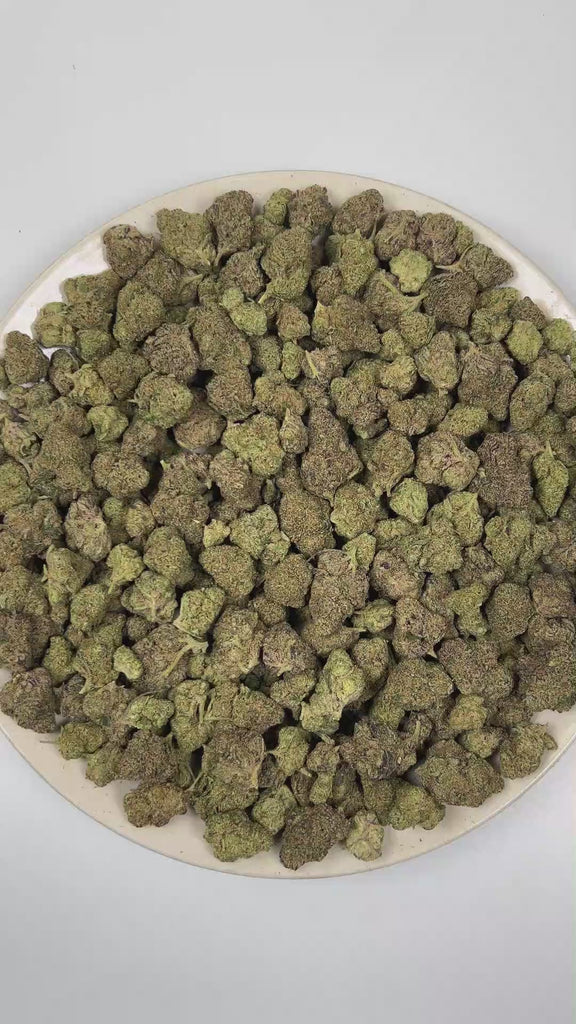 PUFFY Cherry Cough Syrup is an indica-dominant hybrid THCa strain created through the masterful blending of OG Kush × Nigerian Lemon × DPG Pheno. The aroma opens with a burst of ripe cherries and sweet candy notes, layered over a rich fuel-forward undertone. Visually, dense forest green buds with purple hues and fiery orange pistils are coated in sticky trichomes. Consumers often report a euphoric and uplifting mood boost that gradually settles into a deeply relaxing and calming experience. 
