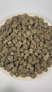 PUFFY Alien Munchies is an indica-dominant hybrid THCa strain derived from the potent genetic collaboration of MAC and Purple Punch 2.0. The aroma is intensely pungent and layered, blending juicy fruity sweetness with a bold gassy funk that lingers in the air and deepens with every inhale. Visually, dense deep forest green buds with purple hues and fiery orange pistils are coated in sticky trichomes. Consumers often report a euphoric, uplifting onset that gradually transitions into a deeply relaxed, calming
