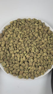 PUFFY Carbon Fiber (smalls) is a balanced hybrid THCa strain, created from a potent blend of Grape Pie, Biscotti, and Cookies & Cream. The aroma unfolds with a rich earthy base, complemented by smooth, creamy notes and a subtle, spicy hint of pepper. Visually, the buds are dense and striking, featuring deep green and purple hues, coated in frosty trichomes and accented with bright orange pistils. Consumers often describe the smoke as creamy and smooth, with a powerful high that feels giggly, tingly, and men
