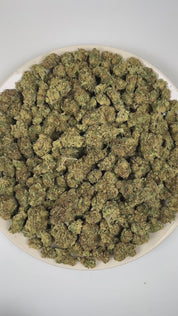 PUFFY Khalifa Kush also known as “Wiz Khalifa” is a legendary hybrid THCa strain originally crafted exclusively for the iconic rapper Wiz Khalifa himself. It is widely regarded as a select phenotype or descendant of OG Kush, often described as an exclusive, highly refined cut of OG Kush–type genetics. The aroma is a bold fusion of kushy earthiness layered with sharp onion-like funk and an intensely pungent, savory edge. Visually, dense green buds with purple hues and fiery orange pistils are coated in stick